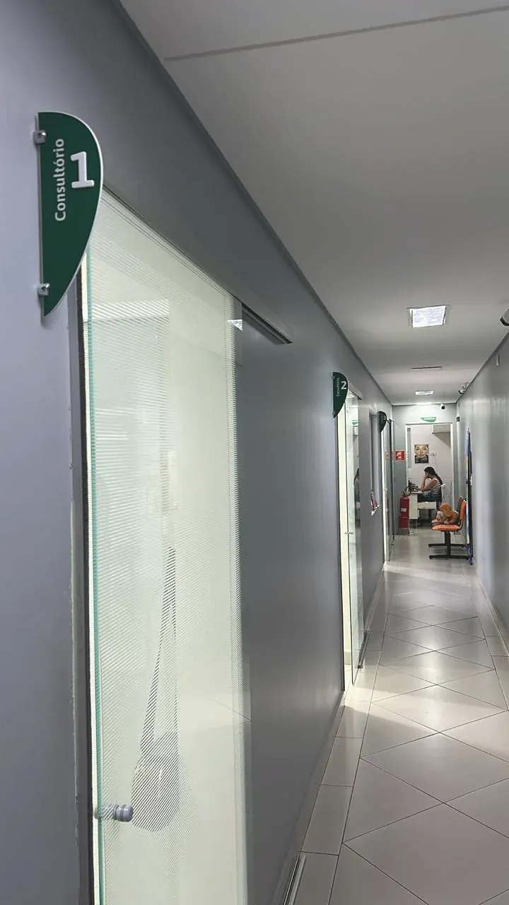 O corredor com as portas de vidro dos consultórios.